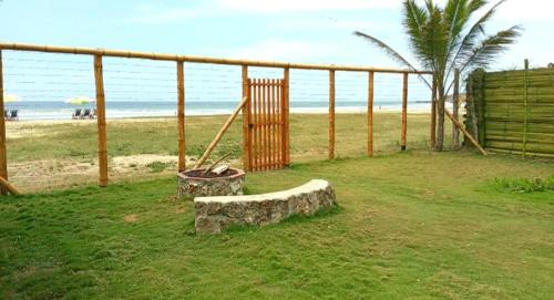 a stone bench sitting on the grass near the beach at Portón Azul in Montañita