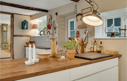 una cocina con encimera de madera y botellas. en Beautiful Home In Stubbekbing With Kitchen, en Stubbekøbing