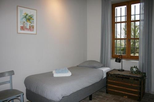 ein kleines Schlafzimmer mit einem Bett und einem Fenster in der Unterkunft Mas des Poutres - Gîte Rose in Charmes-sur-lʼHerbasse