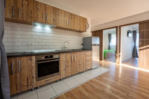 a kitchen with wooden cabinets and a stove top oven at Vila Veve in Sighişoara