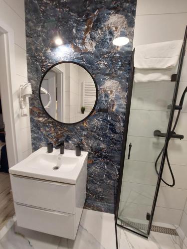 a bathroom with a sink and a mirror at Nadmorski czas Darłówko in Darłowo
