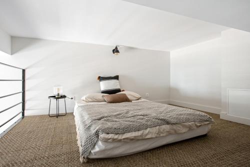 - une chambre dotée d'un lit avec un mur blanc dans l'établissement Studio Francilia - Welkeys, à Nice