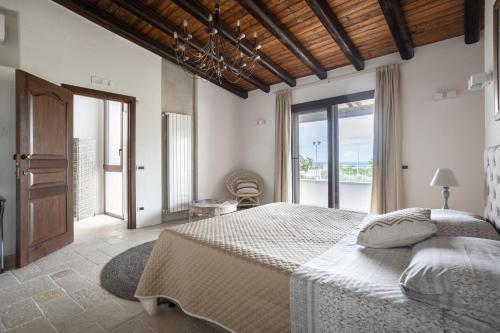 una camera con un grande letto e una grande finestra di Villa a 300 Mt. dal Mare (Magaggiari) con campo da tennis a Cinisi