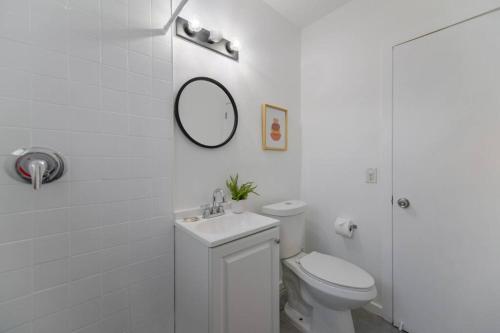 La salle de bains blanche est pourvue de toilettes et d'un miroir. dans l'établissement Wonderful and calm studio in Miami, à Miami