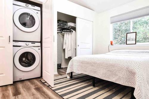 a white bedroom with a washing machine and a bed at Si View in North Bend