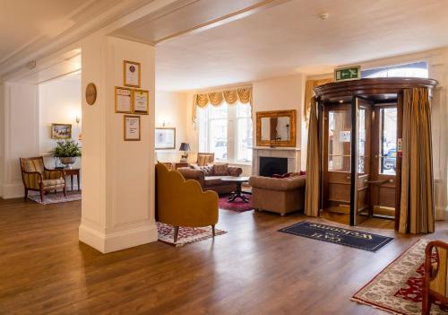 ein Wohnzimmer mit einem Sofa und einem Tisch in der Unterkunft Grant Arms Hotel in Grantown on Spey