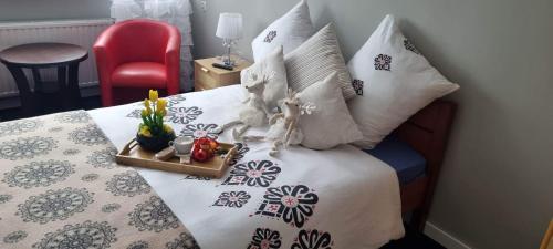 Una cama con almohadas y una bandeja con flores. en Villa Veronika, en Lądek-Zdrój