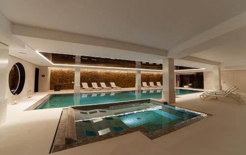 - une grande piscine dans un bâtiment avec piscine dans l'établissement Sport Club Residences & Spa, à Crans-Montana