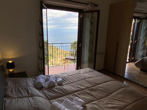 una camera con letto e vista su un balcone di Casa Pasitea a Taormina