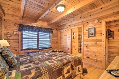 a log cabin bedroom with a bed and a window at Inviting Sevierville Cabin with Deck and Hot Tub! in Sevierville