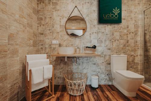 a bathroom with a toilet and a mirror at Limbo Cabañas de Malpica in Malpica