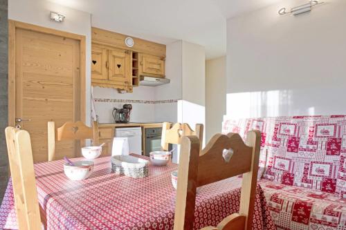 a kitchen with a table with a red and white table cloth at Appartement Stampa - Welkeys in Megève