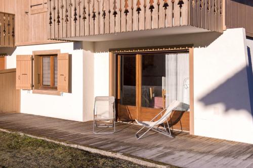 a pair of chairs sitting on a wooden deck at Cosy flat with terrace at the foot of the slopes in Megève - Welkeys in Megève