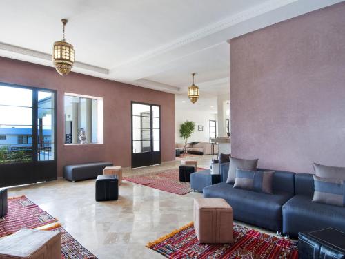 a living room with a blue couch and chairs at Villa Agapanthe in Fès