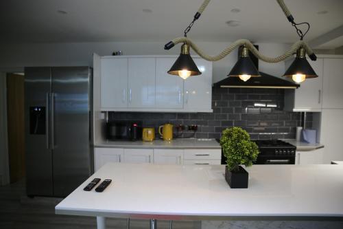 a kitchen with a white table and two lights at Rostron House in Manchester