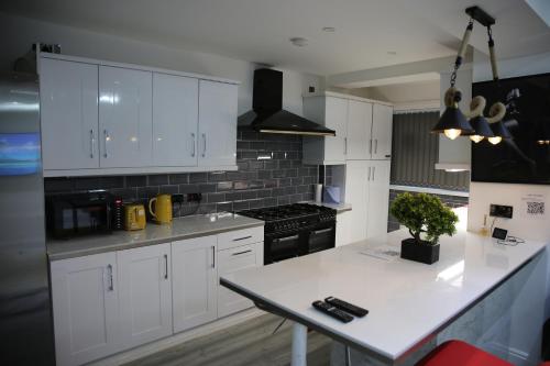 a kitchen with white cabinets and a white counter top at Rostron House in Manchester