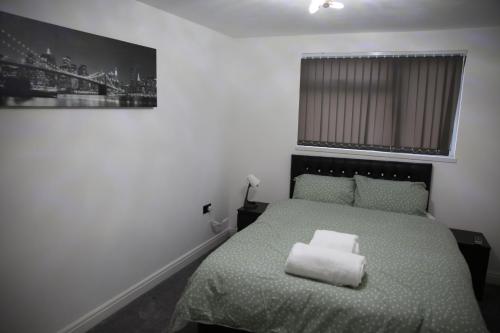 a bedroom with a bed with a white pillow on it at Rostron House in Manchester