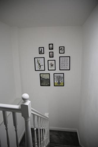 a group of pictures on a wall next to a staircase at Rostron House in Manchester