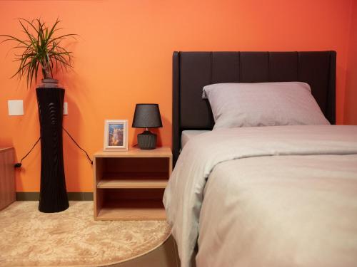 a bedroom with a bed and a plant on a night stand at BOGO Apartment in Bitola