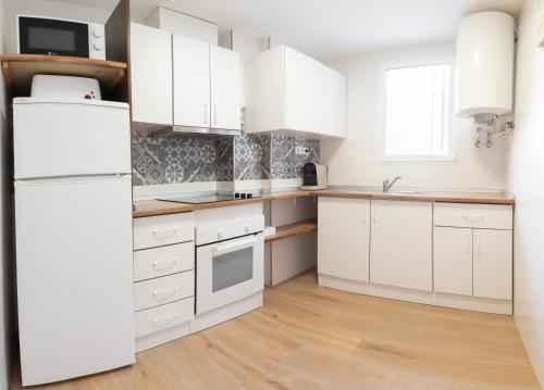 a kitchen with white cabinets and a white refrigerator at Tu Casa en Albacete in Albacete