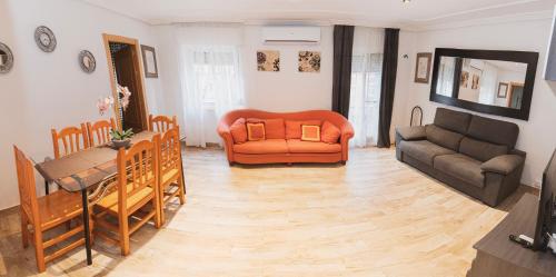 a living room with an orange couch and a table at Tu Casa en Albacete in Albacete