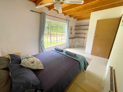 1 dormitorio con cama y ventana grande en The Weaver’s Nest at Riverside, en Winterton