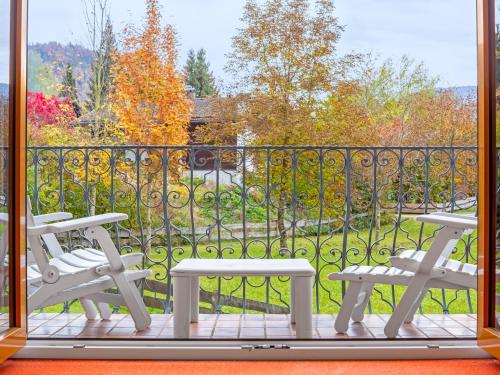 a balcony with two chairs and a view of a park at Landhotel Gabriele in Unterwössen