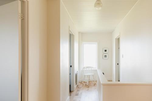 un couloir avec des murs blancs et un plafond blanc dans l'établissement Blanche de l'Ouest - Îles de la Madeleine, à Havre-Aubert