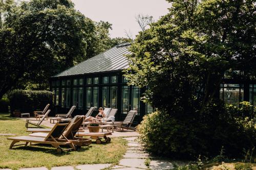 a person sitting on a chair in front of a building at Engø Gård Hotel & Restaurant in Tjøme