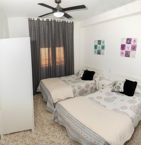 a bedroom with two beds and a ceiling fan at Tu Casa en Albacete in Albacete