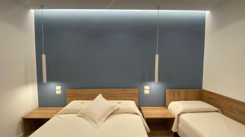 um quarto com 2 camas e uma parede azul em B&B MoMi Sorrento em Sorrento