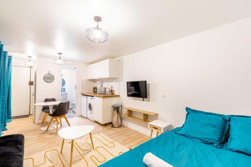 un salon avec un lit et une cuisine dans l'établissement Le Feutrier - Studio au pied du Sacré Coeur, à Paris