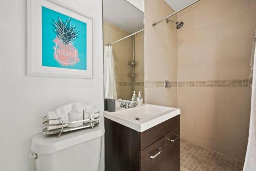 ein Badezimmer mit einem Waschbecken, einem WC und einem Spiegel in der Unterkunft Amazing 3 Bed House with Gameroom and Fun Backyard in North Miami Beach