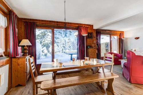 ein Esszimmer mit einem Holztisch und einem Sofa in der Unterkunft Charming flat with garden nearby the slopes - Welkeys in Megève