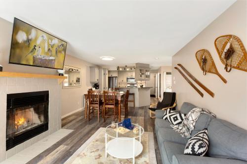 a living room with a couch and a fireplace at Tremblant Rocher Soleil Ski In Ski Out 2 Bedroom in Mont-Tremblant