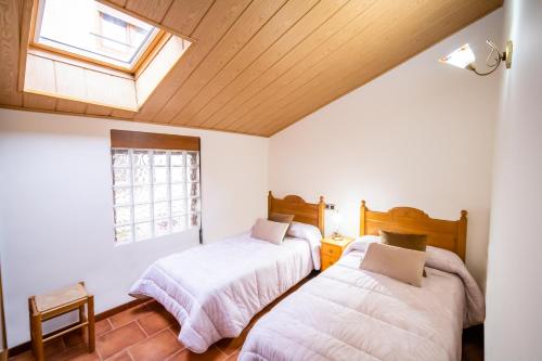 2 Betten in einem Zimmer mit Dachfenster in der Unterkunft CASA TERE in Valderrobres
