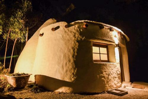 a large mushroom house at night with a window at Valle de Domos - Minas in Minas