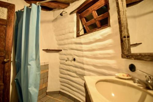 a bathroom with a shower and a sink and a mirror at Valle de Domos - Minas in Minas