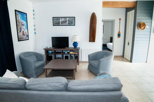 un salon avec un canapé, des chaises et une table dans l'établissement Gite Ferme d'Ervée de Saint-Roch, à Isigny-sur-Mer