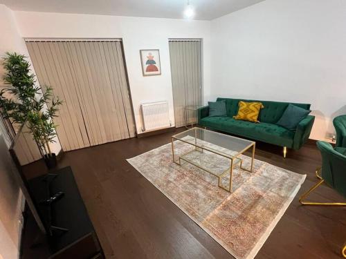 a living room with a green couch and a coffee table at Dartford Lux Stay one bedroom apartment in Dartford