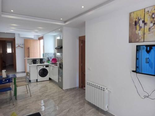 a living room with a kitchen and a dining room at *APPARTEMENT NEUF AVEC TERRASSE À LA MARSA*** in La Marsa