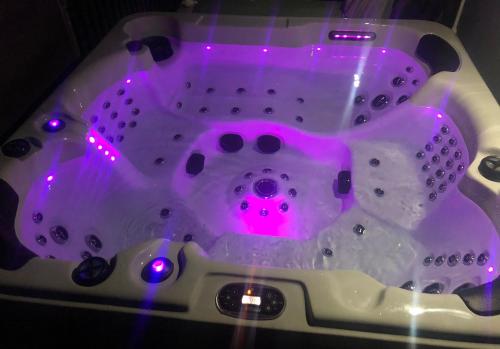 a bath tub with a pink light in it at Black & White in Wadowice