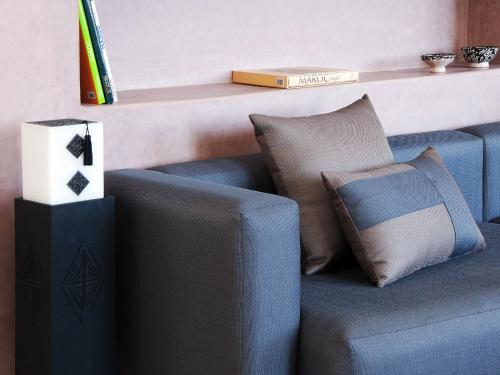 a living room with a blue couch with pillows at Villa Agapanthe in Fès