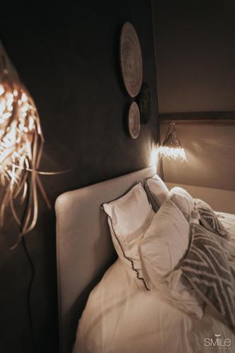 a bedroom with a bed with a pillow and a lamp at Pause Cachée in Walhain-Saint-Paul