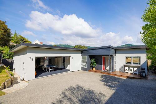a large white house with a driveway at Luxury in Kaiteriteri in Kaiteriteri