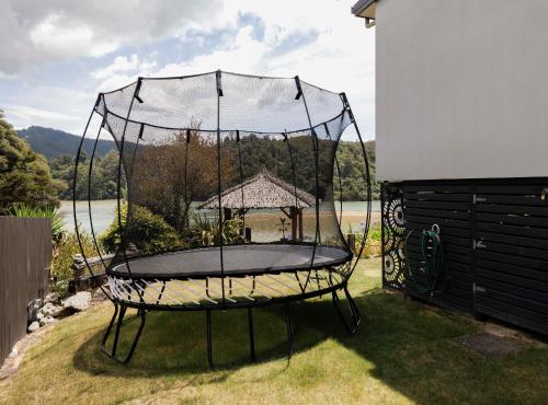 a metal trampoline in a yard with at Luxury in Kaiteriteri in Kaiteriteri