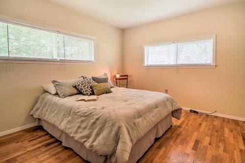 a bedroom with a bed and two windows at Waterfront Osoyoos Lake Cottage with Beach and Patio! in Oroville