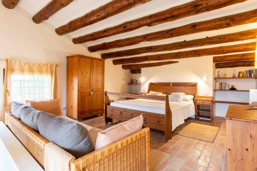 1 dormitorio con 1 cama y 1 sofá en una habitación en Mas Coquells, preciosa masia en plena natura, en Vilanant
