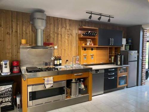 a large kitchen with a stove and a sink at Le clos marin (gîte de charme) in Blendecques