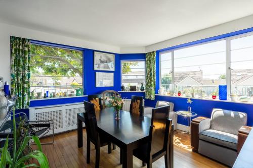 伯青頓的住宿－Twentieth Century B&B，一间拥有蓝色墙壁和桌椅的用餐室